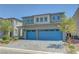 Charming two-story home with a spacious two car garage, landscaped front yard, and blue painted garage doors at 629 Soaring Wings Ave, Las Vegas, NV 89183