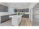 Modern kitchen featuring gray cabinets, a white island, and stainless steel appliances at 629 Soaring Wings Ave, Las Vegas, NV 89183