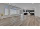 Bright living room featuring wood-look flooring and natural light through the large windows at 629 Soaring Wings Ave, Las Vegas, NV 89183