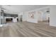 Open-concept living area with wood-look flooring and modern gray kitchen in the background at 629 Soaring Wings Ave, Las Vegas, NV 89183