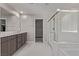 Bright bathroom featuring dual sinks, a glass shower, and a glimpse into the spacious walk-in closet at 6909 Toll Mountain St, North Las Vegas, NV 89086