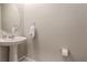 Well-lit half bathroom features a pedestal sink and round mirror at 6909 Toll Mountain St, North Las Vegas, NV 89086