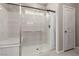 Modern bathroom with a glass-enclosed shower featuring a seat and a sleek shower head at 6909 Toll Mountain St, North Las Vegas, NV 89086