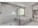 Modern bathroom showcasing a glass shower, soaking tub, and bright natural light at 6909 Toll Mountain St, North Las Vegas, NV 89086