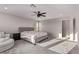 Bright bedroom boasts natural light, neutral tones, soft carpet, and a cozy chair for comfort at 6909 Toll Mountain St, North Las Vegas, NV 89086