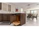 View of kitchen island with storage, dining table and living area featuring an open-concept design at 6909 Toll Mountain St, North Las Vegas, NV 89086