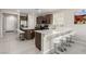 Modern kitchen features an island with bar seating, stainless steel appliances, and tile floors at 6909 Toll Mountain St, North Las Vegas, NV 89086