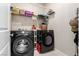Laundry room featuring front loading washer and dryer with shelving at 6909 Toll Mountain St, North Las Vegas, NV 89086