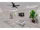 A relaxing living room with a sofa, tv, indoor plant, and modern furnishings at 6909 Toll Mountain St, North Las Vegas, NV 89086