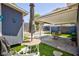 Backyard with patio, a covered seating area, artificial turf, a small shed, and mature desert landscaping at 6924 Senton Ave, Las Vegas, NV 89108