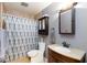 Bathroom features shower with curtain, toilet, vanity with sink, and mirrored cabinet at 6924 Senton Ave, Las Vegas, NV 89108