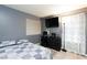 This bedroom features a large window, mounted TV and tile flooring at 6924 Senton Ave, Las Vegas, NV 89108