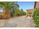 Expansive backyard features gravel landscaping, mature trees, and a charming pergola at 7559 Chambery Cove Ct, Las Vegas, NV 89123