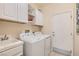 Well-lit laundry room features a washer, dryer, sink, and ample storage cabinets at 7559 Chambery Cove Ct, Las Vegas, NV 89123