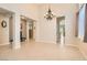 Spacious living room featuring tile flooring, neutral colors, and elegant chandelier at 7559 Chambery Cove Ct, Las Vegas, NV 89123