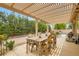Covered patio with outdoor dining set and lush greenery, perfect for entertaining at 7559 Chambery Cove Ct, Las Vegas, NV 89123