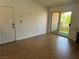Inviting living room with wood floors and a sliding glass door leading to outdoor patio with faux grass at 7885 W Flamingo Rd # 2129, Las Vegas, NV 89147