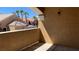 Cozy balcony with stucco wall overlooking palm trees and other residential buildings at 8101 W Flamingo Rd # 2110, Las Vegas, NV 89147