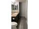 Standard bathroom featuring dark wood cabinets, laminate countertops, and wood-look vinyl flooring at 8101 W Flamingo Rd # 2110, Las Vegas, NV 89147