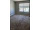 Bright bedroom featuring a large window with a view, plush carpet, and neutral color scheme at 8101 W Flamingo Rd # 2110, Las Vegas, NV 89147