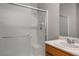 Bathroom featuring glass door shower, vanity with white sink, and tiled walls at 9136 Cocowoods Pl, Las Vegas, NV 89148