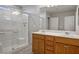 Bright bathroom features a double sink vanity and a glass enclosed shower with tiled walls at 9136 Cocowoods Pl, Las Vegas, NV 89148