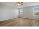Large bedroom with wood flooring, a ceiling fan, and two windows at 9136 Cocowoods Pl, Las Vegas, NV 89148