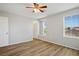 Bright bedroom features wood-look flooring, fan, two windows and neutral walls at 9136 Cocowoods Pl, Las Vegas, NV 89148
