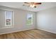 Spacious bedroom with ceiling fan, two windows, and wood look flooring at 9136 Cocowoods Pl, Las Vegas, NV 89148