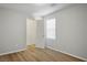 Neutral bedroom with natural light, featuring wood floors, white trim, and a closet at 9136 Cocowoods Pl, Las Vegas, NV 89148