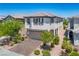 Charming two-story home featuring a well-manicured front yard with a brick driveway at 9136 Cocowoods Pl, Las Vegas, NV 89148