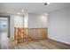 Upstairs hallway with wood railing, wood flooring, and two doors at 9136 Cocowoods Pl, Las Vegas, NV 89148