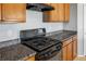 Close up of a kitchen with granite countertops, wood cabinets, and stainless steel appliances at 9136 Cocowoods Pl, Las Vegas, NV 89148