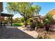 Beautiful backyard space with mature landscaping and a cozy patio area at 1004 Viale Placenza Pl, Henderson, NV 89011