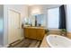 Bright bathroom featuring double sinks, a soaking tub, and a window for natural light at 1004 Viale Placenza Pl, Henderson, NV 89011