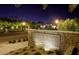 Elegant community entrance sign at night with stone accents and lush landscaping at Tuscany Village and Golf at 1004 Viale Placenza Pl, Henderson, NV 89011