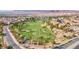 Scenic aerial view of Chimera Golf Club showcasing lush green fairways, palm trees, and community roads at 1004 Viale Placenza Pl, Henderson, NV 89011