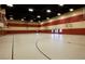 Spacious gymnasium with basketball hoops, striped walls, and ample room for various sports and activities at 1004 Viale Placenza Pl, Henderson, NV 89011