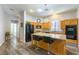 Charming kitchen with an island featuring seating, wood cabinetry, and sleek black appliances at 1004 Viale Placenza Pl, Henderson, NV 89011