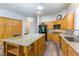 Spacious kitchen showcasing a large granite island, wooden cabinets, and modern black appliances at 1004 Viale Placenza Pl, Henderson, NV 89011