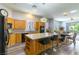 Well-lit kitchen with a large island, modern appliances, and wood-look flooring flowing into the dining area at 1004 Viale Placenza Pl, Henderson, NV 89011