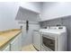 This laundry room is equipped with a washer, dryer, and storage shelves at 1004 Viale Placenza Pl, Henderson, NV 89011