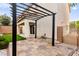 The paved patio, with pergola, leads to a synthetic lawn for easy upkeep, creating a charming outdoor living space at 10557 Bandera Mountain Ln, Las Vegas, NV 89166