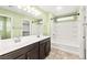 Bright bathroom features a dual sink vanity, tub-shower with a white tile surround, and modern fixtures at 10557 Bandera Mountain Ln, Las Vegas, NV 89166