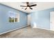 Empty bedroom featuring blue walls, carpet flooring, a window, and a ceiling fan at 10557 Bandera Mountain Ln, Las Vegas, NV 89166