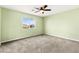 Spacious bedroom with neutral carpeting, large window, and ceiling fan at 10557 Bandera Mountain Ln, Las Vegas, NV 89166