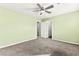 A large bedroom with a ceiling fan, neutral carpet, and a view of the bedroom door and closet at 10557 Bandera Mountain Ln, Las Vegas, NV 89166