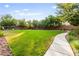 The common area is beautifully landscaped with a sidewalk, green grass, trees, and manicured bushes at 10557 Bandera Mountain Ln, Las Vegas, NV 89166