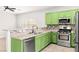 Bright kitchen featuring stainless appliances, green cabinets, and granite countertops at 10557 Bandera Mountain Ln, Las Vegas, NV 89166