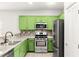 Kitchen featuring stainless steel appliances, green cabinetry, and tile backsplash at 10557 Bandera Mountain Ln, Las Vegas, NV 89166